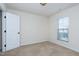 Bright carpeted bedroom with a window, neutral colors, and white door at 628 Denhoff Dr, Cary, NC 27519