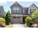 Charming townhome featuring a brick facade, attached garage, and well-maintained landscaping at 628 Denhoff Dr, Cary, NC 27519