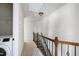 Upstairs hallway with carpet and wood railing, also featuring a laundry closet at 628 Denhoff Dr, Cary, NC 27519