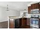 Eat-in kitchen with stainless appliances, tile backsplash, granite counters, and dark wood cabinetry at 628 Denhoff Dr, Cary, NC 27519