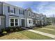 New townhomes with vinyl siding, stone accents, manicured lawns, and concrete sidewalks on a sunny day at 6443 Granite Quarry Dr, Raleigh, NC 27610