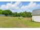 Large grassy backyard enclosed with a wood fence and a few scattered trees and shrubs at 71 Havistock Ct, Cameron, NC 28326