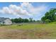 Expansive backyard with a mix of lush and dry grass, enclosed by a wooden fence and some trees at 71 Havistock Ct, Cameron, NC 28326