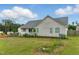 Backyard view showing the house exterior with a deck, surrounded by green grass and some trees at 71 Havistock Ct, Cameron, NC 28326