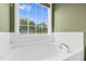 A white tub with a window that overlooks the yard at 71 Havistock Ct, Cameron, NC 28326