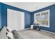 A blue bedroom with a gray couch and a large window at 71 Havistock Ct, Cameron, NC 28326