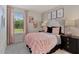 Charming bedroom featuring a stylish bed, neutral walls, and an abundance of natural light from the window at 711 Chandler Stone Dr, Zebulon, NC 27597