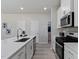 Well-lit kitchen featuring white cabinets, stainless appliances, and a spacious center island with a sink at 711 Chandler Stone Dr, Zebulon, NC 27597