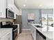 Modern kitchen with white cabinets, stainless appliances, and an island with seating overlooking dining area at 711 Chandler Stone Dr, Zebulon, NC 27597