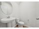 A half bathroom features a round mirror, white fixtures, and wood-look flooring at 713 Chandler Stone Dr, Zebulon, NC 27597