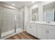 Bathroom featuring dual sinks, white cabinets, glass shower, and wood-look flooring at 713 Chandler Stone Dr, Zebulon, NC 27597
