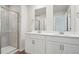 Bathroom featuring dual sinks, white cabinets, glass shower, and modern fixtures at 713 Chandler Stone Dr, Zebulon, NC 27597