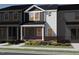 Charming townhome with brick accents, a covered porch, and a professionally landscaped yard with vibrant flowers at 713 Chandler Stone Dr, Zebulon, NC 27597