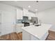 Modern kitchen features white cabinets, stainless steel appliances, and a large island with a quartz countertop at 713 Chandler Stone Dr, Zebulon, NC 27597