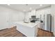 Modern kitchen with stainless steel appliances, a center island, white cabinets, and hardwood floors at 713 Chandler Stone Dr, Zebulon, NC 27597