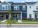 Attractive townhome featuring blue and white exterior, a well-maintained lawn, and a sidewalk at 715 Chandler Stone Dr, Zebulon, NC 27597