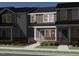 Charming townhome exterior featuring a modern color scheme, brick accents, and landscaped front yard at 715 Chandler Stone Dr, Zebulon, NC 27597
