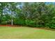 Well-manicured backyard featuring a lush lawn, trees, and mulch bed at 802 Windermere Lake Ct, Apex, NC 27502