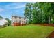 Large backyard featuring a well-maintained lawn, deck, and wooded area at 802 Windermere Lake Ct, Apex, NC 27502