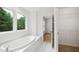 Bright bathroom with garden tub, window view, and open closet space at 802 Windermere Lake Ct, Apex, NC 27502