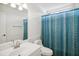 Bright bathroom featuring a blue shower curtain, white vanity, and ample mirror space at 802 Windermere Lake Ct, Apex, NC 27502