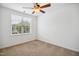 Bright bedroom with neutral carpet, ceiling fan, and natural light from a large window at 802 Windermere Lake Ct, Apex, NC 27502
