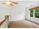 Upstairs bedroom featuring a ceiling fan, window with bamboo blind, and neutral carpet at 802 Windermere Lake Ct, Apex, NC 27502