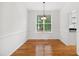 Cozy dining room features hardwood floors, wainscoting, a modern chandelier, and a window at 802 Windermere Lake Ct, Apex, NC 27502