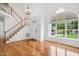 Bright foyer features hardwood floors, a staircase, a high ceiling, and a large window at 802 Windermere Lake Ct, Apex, NC 27502