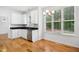 Bright eat-in kitchen with white cabinets, stainless appliances, granite countertops, and hardwood floors at 802 Windermere Lake Ct, Apex, NC 27502