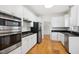 Modern kitchen with stainless steel appliances, white cabinets, and hardwood floors at 802 Windermere Lake Ct, Apex, NC 27502