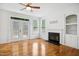 Bright living room with hardwood floors, a fireplace, a ceiling fan, and access to the deck at 802 Windermere Lake Ct, Apex, NC 27502