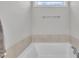 Corner of the bathroom features a soaking tub with tile surround and a small window above at 9 Little Sunshine Brk, Smithfield, NC 27577