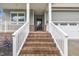 Close-up of the brick stairs leading up to the covered front porch with white railings at 9 Little Sunshine Brk, Smithfield, NC 27577