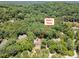 Expansive aerial view of 90021 Hoey, nestled among lush trees with a serene lake nearby at 90021 Hoey, Chapel Hill, NC 27517
