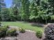 Well-manicured backyard with lush greenery, mature trees, and decorative landscaping for serene outdoor living at 90021 Hoey, Chapel Hill, NC 27517