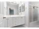 Bright bathroom with double vanity sinks, framed mirrors, and a glass door shower at 90021 Hoey, Chapel Hill, NC 27517
