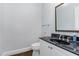 Powder room with black countertop, white cabinets, and classic fixtures at 90021 Hoey, Chapel Hill, NC 27517