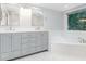 Bathroom features double vanity, a soaking tub, tile flooring, and a large window at 90021 Hoey, Chapel Hill, NC 27517