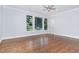 A bedroom features hardwood floors, a ceiling fan, and a wall of windows at 90021 Hoey, Chapel Hill, NC 27517