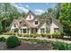 Charming two-story home with white brick and manicured landscaping, set amongst mature trees at 90021 Hoey, Chapel Hill, NC 27517
