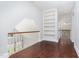 Upstairs hallway with hardwood floors, railing, and custom built-in shelving at 90021 Hoey, Chapel Hill, NC 27517