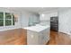 Modern kitchen with stainless steel appliances, light gray cabinets, hardwood floors, and white countertops at 90021 Hoey, Chapel Hill, NC 27517