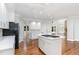 Bright, open kitchen featuring white cabinetry, quartz countertops, and stainless steel appliances at 90021 Hoey, Chapel Hill, NC 27517