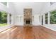 Bright open living room with a stone fireplace, built-in shelving, and rich hardwood floors at 90021 Hoey, Chapel Hill, NC 27517