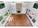 A spacious living room with a stone fireplace, built-in shelving, wood floors, and bright natural light at 90021 Hoey, Chapel Hill, NC 27517
