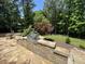 Beautiful outdoor kitchen featuring a built-in grill, stone countertops, and a large patio for outdoor dining at 90021 Hoey, Chapel Hill, NC 27517