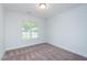 A clean bedroom features neutral walls and carpet, with natural light from a window at 905 Alice Ct, Haw River, NC 27258