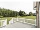 Back deck with white railings overlooking a green lawn and green trees in the background at 9123 Thomas Rd, Rocky Mount, NC 27803