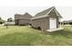 Backyard view featuring a brick outbuilding and attached garage on a well maintained lawn at 9123 Thomas Rd, Rocky Mount, NC 27803